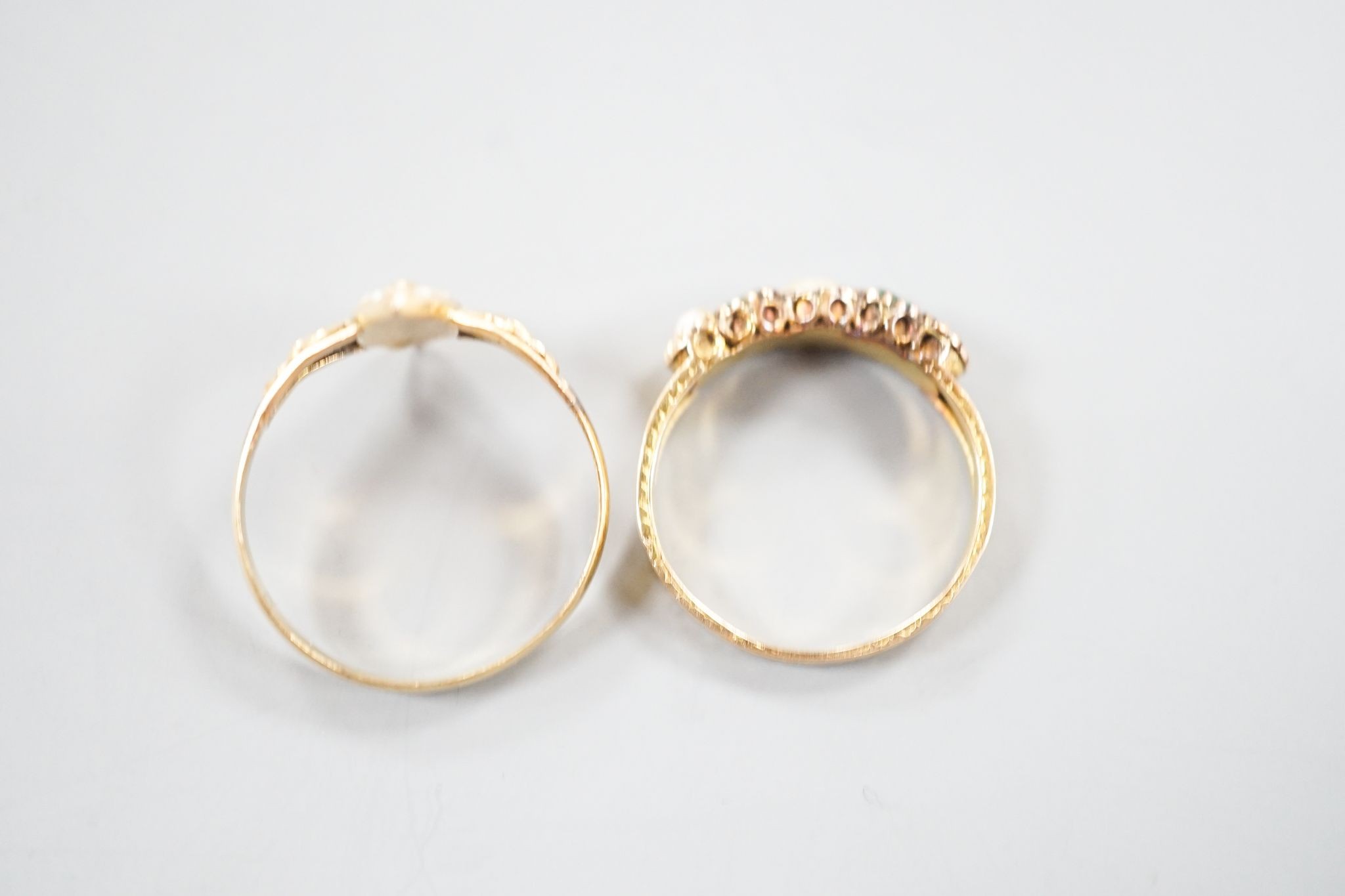 A Victorian 15ct gold, emerald and split pearl set five stone half hoop ring, size M, gross 1.9 grams and an early 20th century yellow metal and seed pearl set dress ring, size O, gross 1.7 grams.